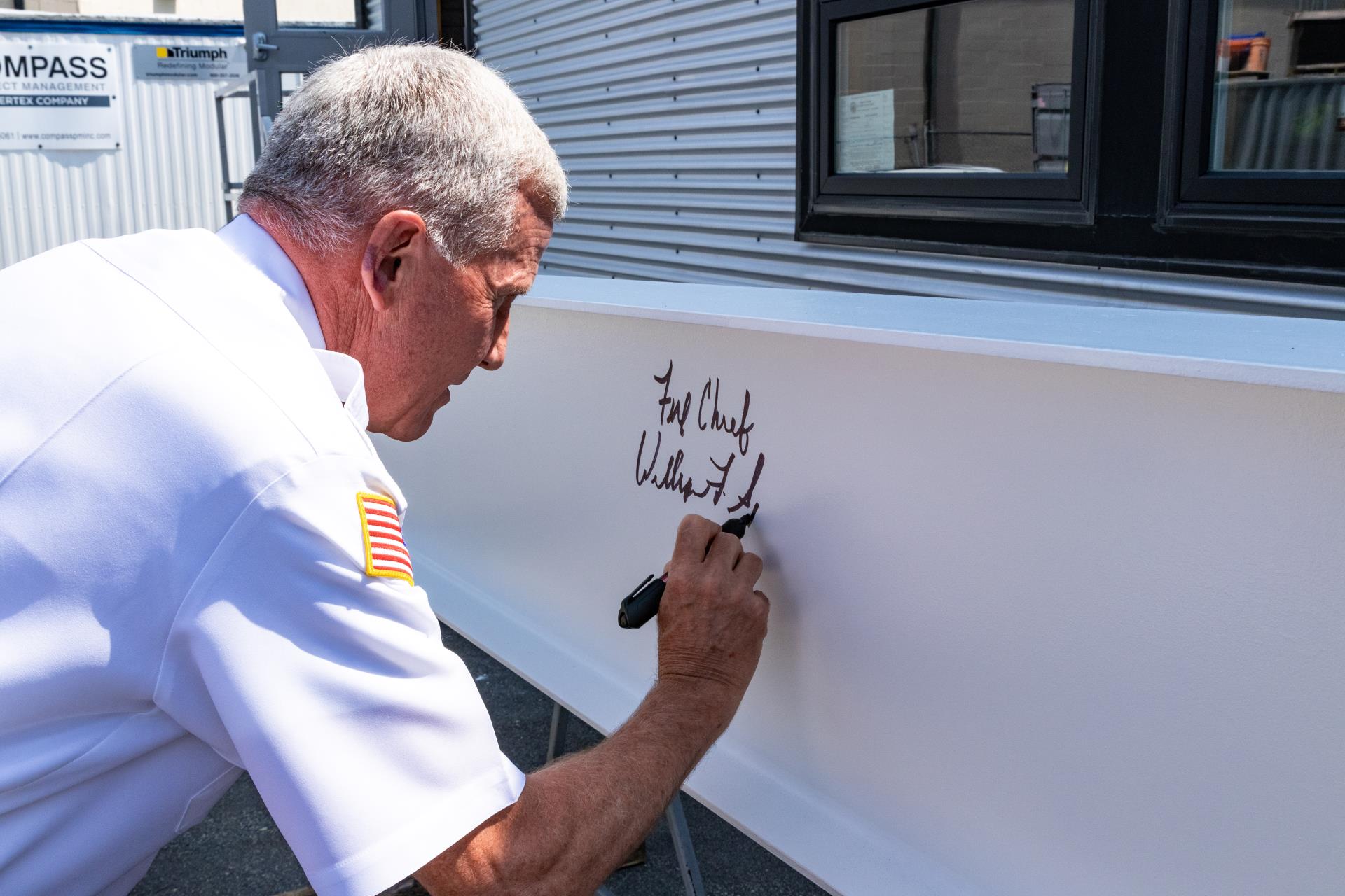 Fire Chief Spillane is the first to sign the beam